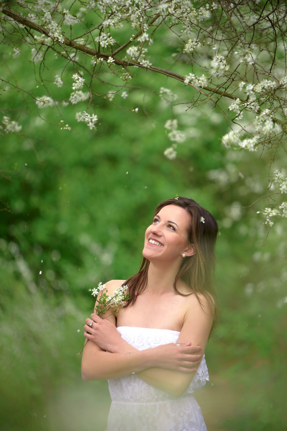 Aneta Štěpánková mezi kvetoucími stromy držící větvičky s květy