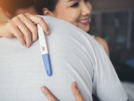 Šťastná žena s těhotenským testem